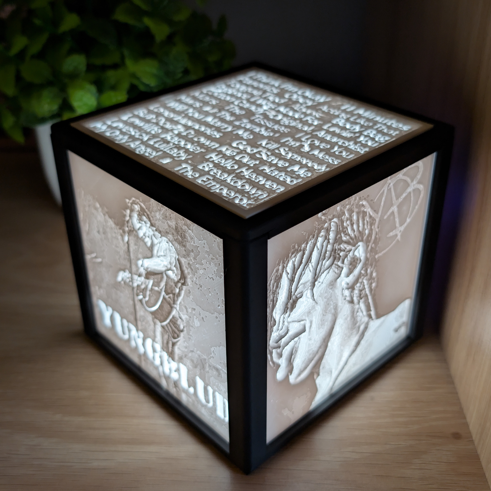 Black framed lithophane light box with music artwork and a track list panel